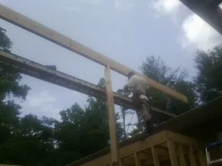 Carpenter setting a ridge beam over a new addition frame — Ice Dam Removal by Roofing Brothers in Hartington