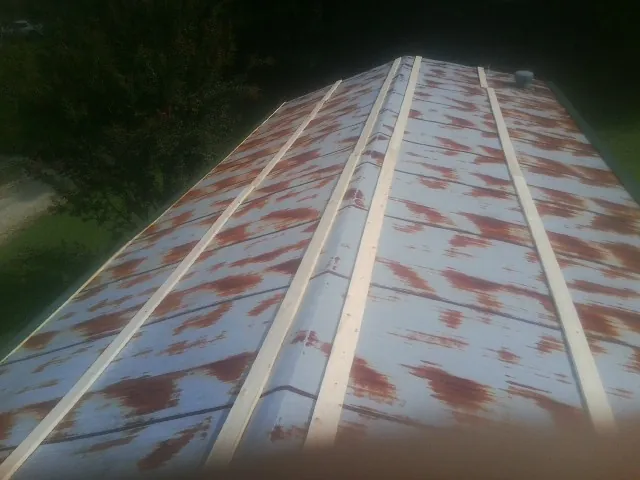Rusted metal roof panels with new wood purlins before replacement — Storm Damage Roof Repair in Hartington by Roofing Brothers